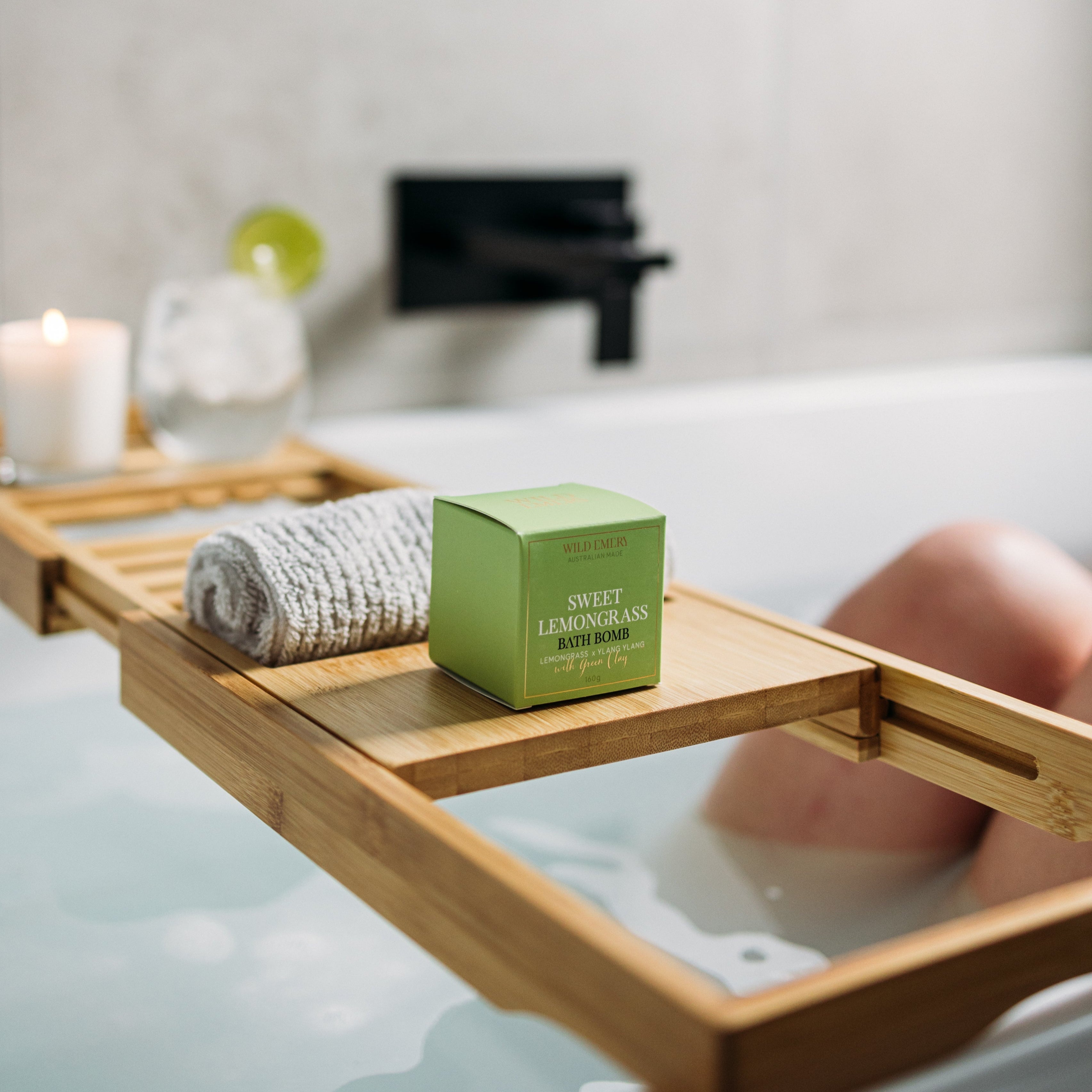 Bath tray with a Sweet Lemongrass Bath bomb in a bathtub setting