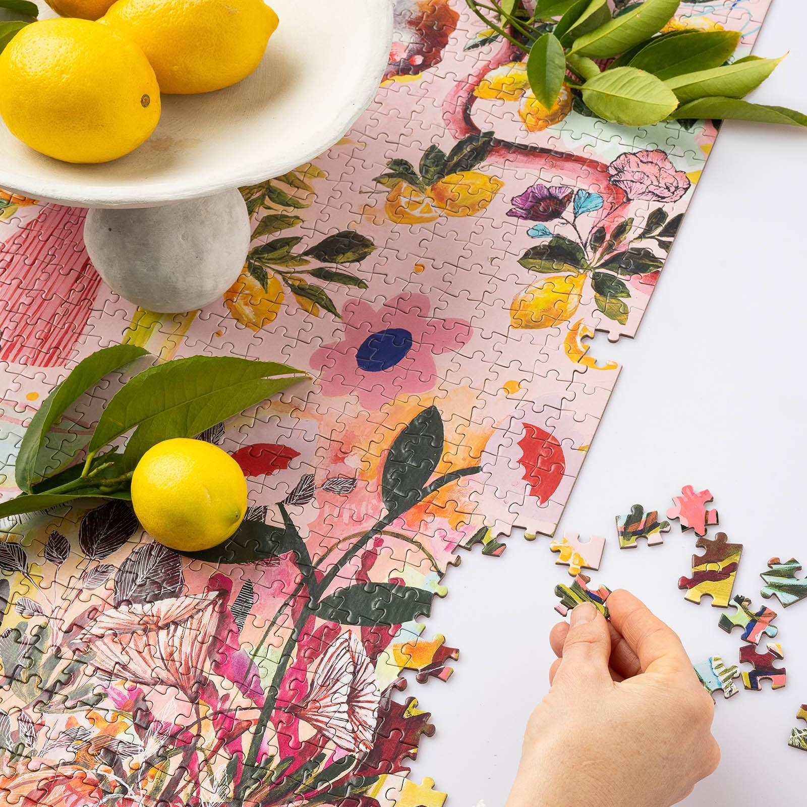 Colorful puzzle with lemons and leaves on a floral-patterned surface.
